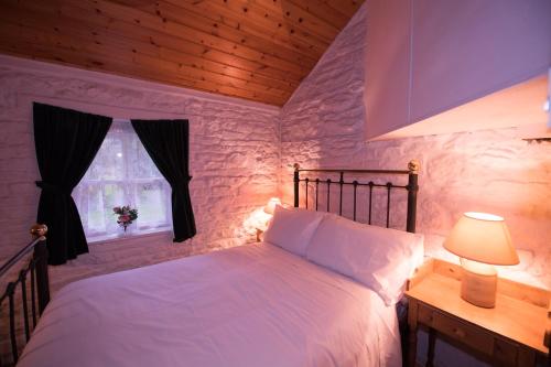 a bedroom with a white bed and a window at Railway Crossing Cottage in Murlas Bridge