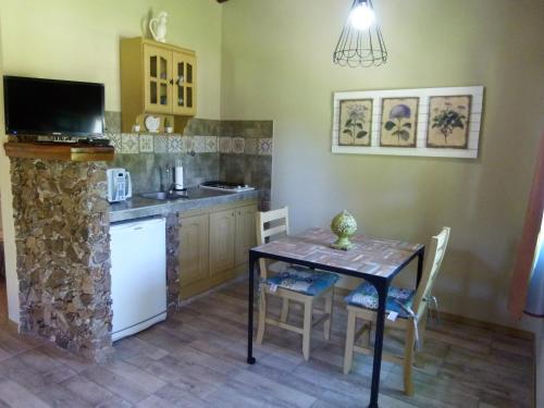 a kitchen with a table and a small kitchen with a stove at Guidai Bilu in San José