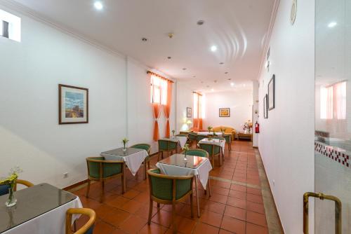 a restaurant with tables and chairs in a room at Colina do Mar in Albufeira