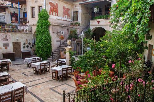 an outdoor patio with tables and chairs and plants at Sofa Hotel in Avanos