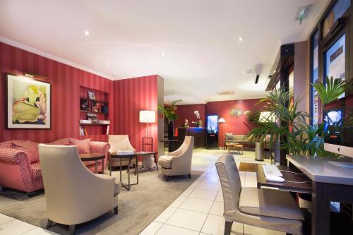 ein Restaurant mit roten Wänden, Stühlen und Tischen in der Unterkunft Europe Hotel Paris Eiffel in Paris
