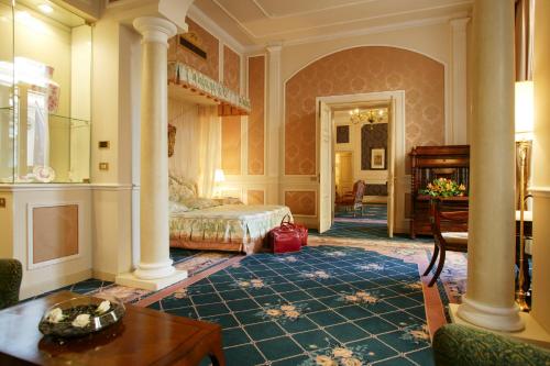 a bedroom with a bed and a table in a room at Grand Hotel Majestic gia' Baglioni in Bologna