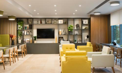 a waiting room with yellow chairs and a flat screen tv at Park Inn by Radisson Istanbul Atasehir in Istanbul