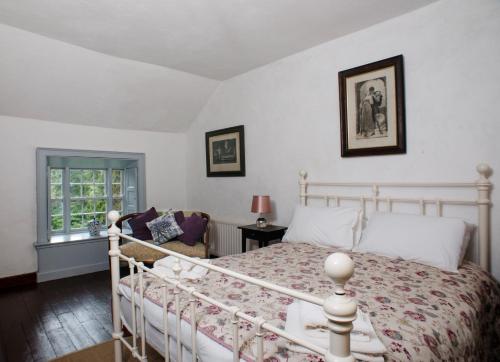1 dormitorio con cama blanca y ventana en Knocknalosset House, en Canningstown