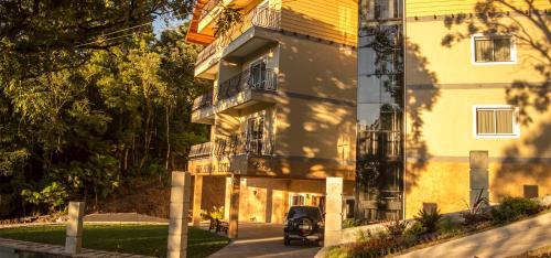 a yellow building with a car parked in front of it at Sky Serra Hotel in Gramado