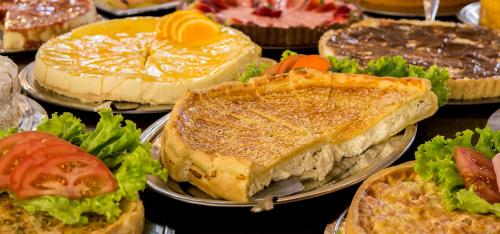 a bunch of sandwiches and vegetables on plates at Sky Serra Hotel in Gramado