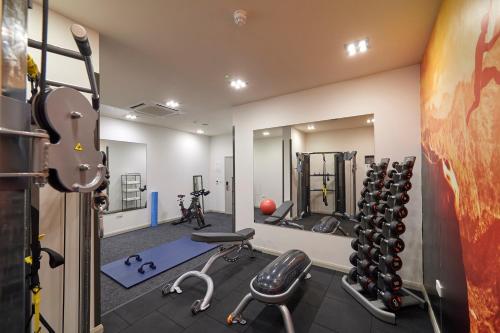 a gym with a lot of equipment in a room at The Lodge Hotel - Putney in London