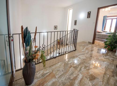 a lobby with a staircase and a vase with flowers at South Olives in Żejtun