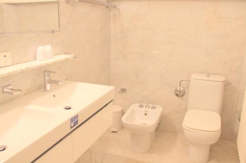 a white bathroom with a toilet and a sink at Barony Le Pergole Lugano Villa for 8 persons in Lugano