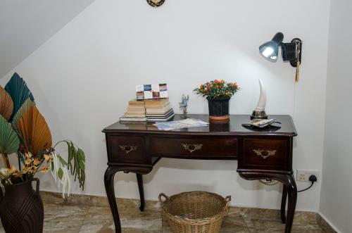 a desk with books on it next to a wall at South Olives in Żejtun