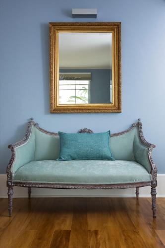 a blue couch in a room with a mirror at Hotel Isla Seca in Zapallar