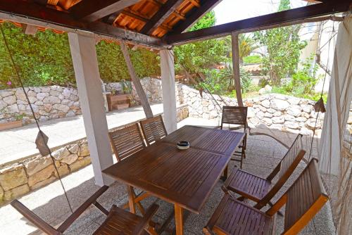 einen Holztisch und Stühle auf einer Terrasse in der Unterkunft Apartments Ana in Mali Lošinj