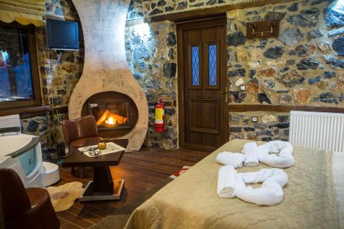 a room with a fireplace and a bed with towels at Guesthouse Elati - Pella in Palaios Agios Athanasios
