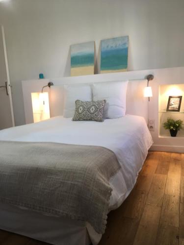 une chambre avec un grand lit blanc avec deux lampes dans l'établissement Charme Méditerranéen Votre pied à terre au Cœur du Port de Nice, à Nice
