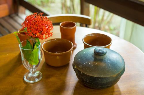 a wooden table with a vase and flowers on it at Paraty Villa d`agua Temporada in Paraty