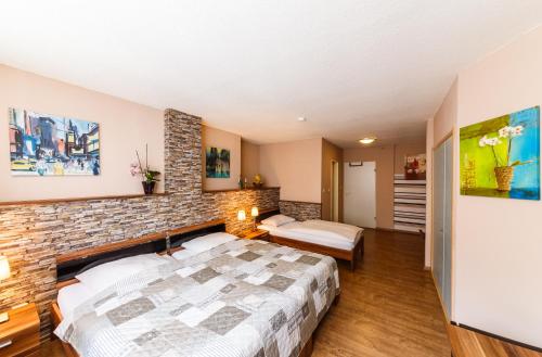 a bedroom with a bed and a brick wall at City Hotel Stolberg in Stolberg