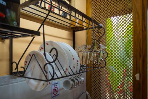 a bunch of dishes on a drying rack in a kitchen at Paraty Villa d`agua Temporada in Paraty