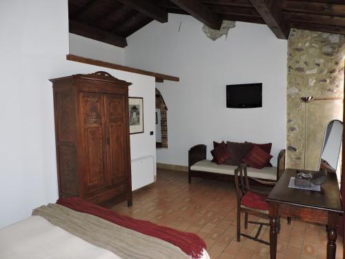 a bedroom with a bed and a cabinet and a couch at Agriturismo Sambuco in Pastrengo