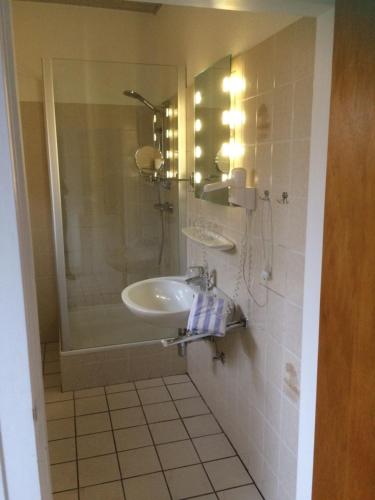 a bathroom with a sink and a shower at Ferienwohnanlage Sturmhöhe in Welt