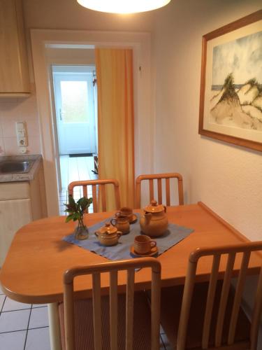 a dining room table with four bowls on it at Ferienwohnanlage Sturmhöhe in Welt