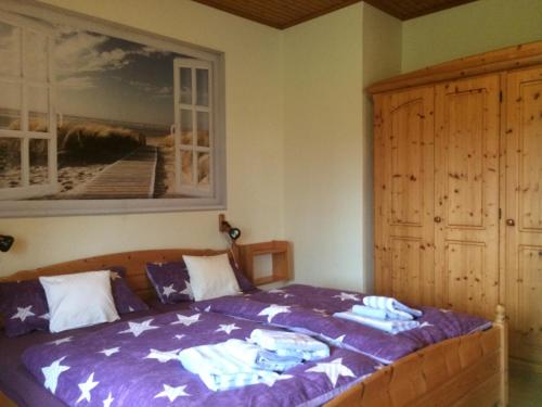 a bedroom with a bed with a painting on the wall at Ferienwohnanlage Sturmhöhe in Welt