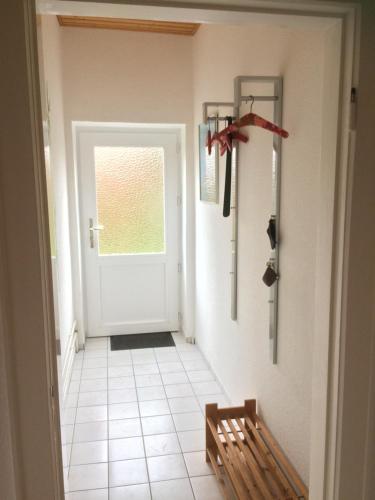 a hallway with a white door and a bench at Ferienwohnanlage Sturmhöhe in Welt