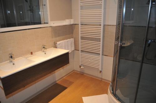 a bathroom with two sinks and a shower at Medjugorje Hotel & Spa in Međugorje