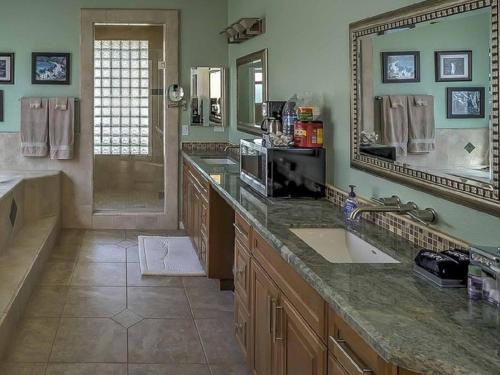 a large bathroom with a sink and a large mirror at Sweet Wildomar Retreat in Wildomar