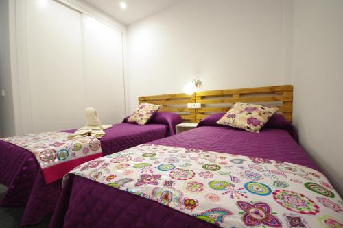 コニル・デ・ラ・フロンテーラにあるChalet Deluxe Wifi Gratisの紫色のシーツと枕が備わる客室内のベッド2台