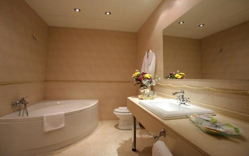 a bathroom with a tub and a toilet and a sink at Hotel Castillo Bonavía in Pedrola