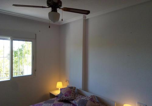 una camera con ventilatore a soffitto e letto di Casa Montemar Algorfa Spain a Castillo de Montemar
