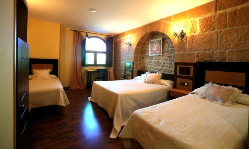 a hotel room with two beds and a window at Hotel Castillo Bonavía in Pedrola