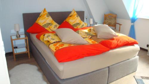 una cama con almohadas coloridas en una habitación en Ferienwohnung Mebes en Polle