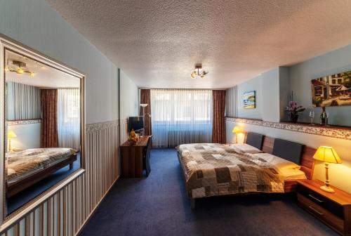 a hotel room with two beds and a mirror at City Hotel Stolberg in Stolberg