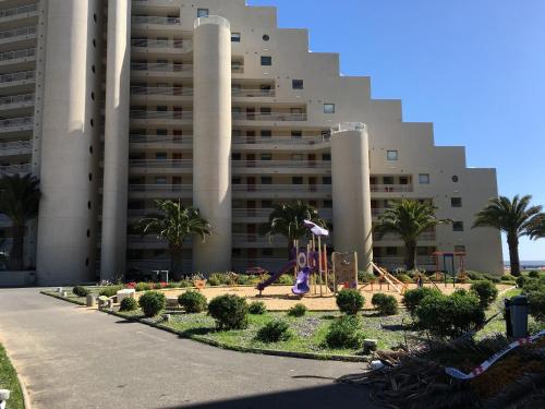 a large building with a playground in front of it at Duplex Jacuzzi San Alfonso del Mar in Algarrobo