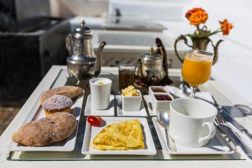 索維拉的住宿－Riad MALAÏKA，一张桌子,上面放着两盘早餐食品和饮料