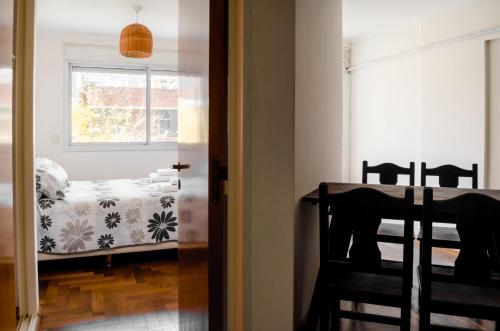 a room with a table and a bed with a window at Lofty Departamentos Temporarios in Cordoba