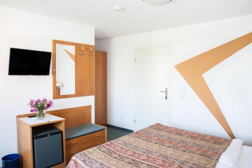 a bedroom with a bed and a mirror at Insel-Hof Reichenau Hotel-garni in Reichenau