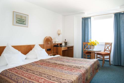 A bed or beds in a room at Insel-Hof Reichenau Hotel-garni