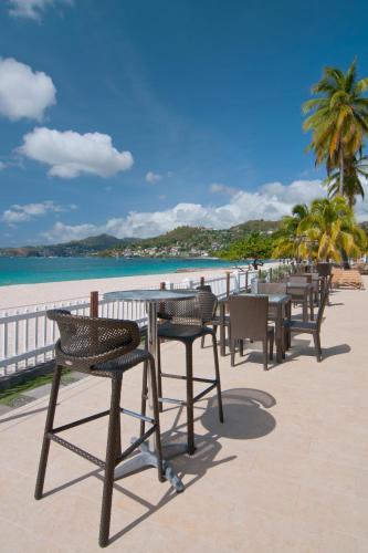 a row of tables and chairs on the beach at Radisson Grenada Beach Resort in Grand Anse
