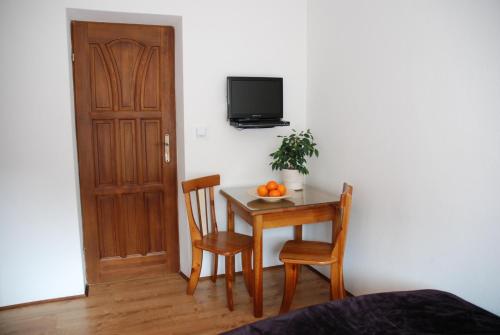 a room with a table with two chairs and a television at Willa Gościnny Próg in Krościenko