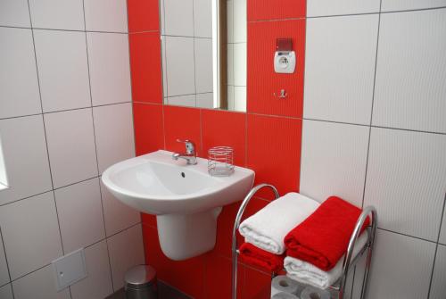 a red and white bathroom with a sink and a mirror at Willa Gościnny Próg in Krościenko