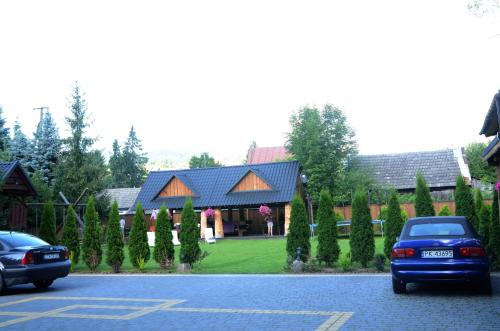 a car parked in a parking lot in front of a house at Willa Gościnny Próg in Krościenko