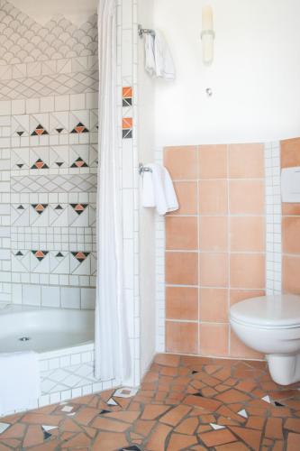 a bathroom with a tub and a toilet at Insel-Hof Reichenau Hotel-garni in Reichenau