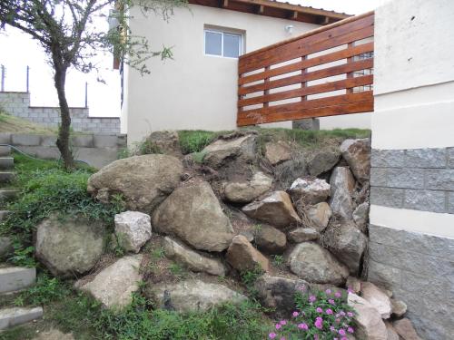 un montón de rocas delante de una casa en Cabañas Doña Itati, en Villa Carlos Paz