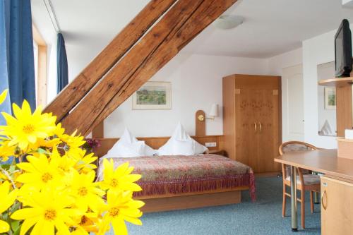a bedroom with a bed with yellow flowers at Insel-Hof Reichenau Hotel-garni in Reichenau