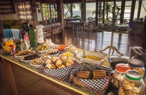 ein Buffet mit vielen verschiedenen Speisen auf einem Tisch in der Unterkunft Pousada The Rosebud in Praia do Rosa