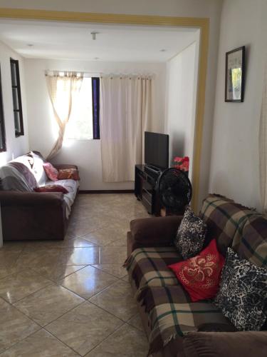 a living room with two couches and a television at Linda casa na Praia do Flamengo in Salvador