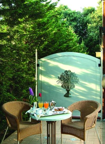 a patio with a table and two chairs and a garage at Montespina Park Hotel in Naples