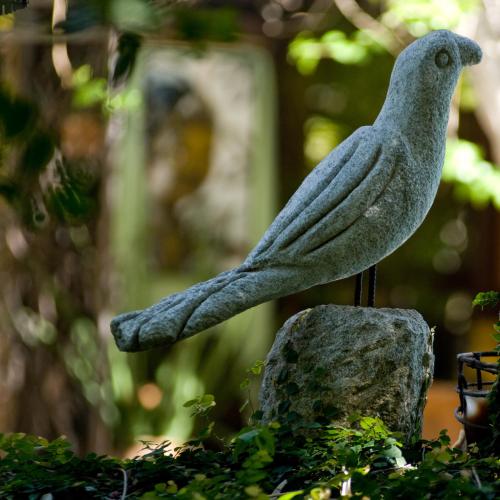 a statue of a bird sitting on a rock at Vilangelim Eco-Pousada in Imbassai
